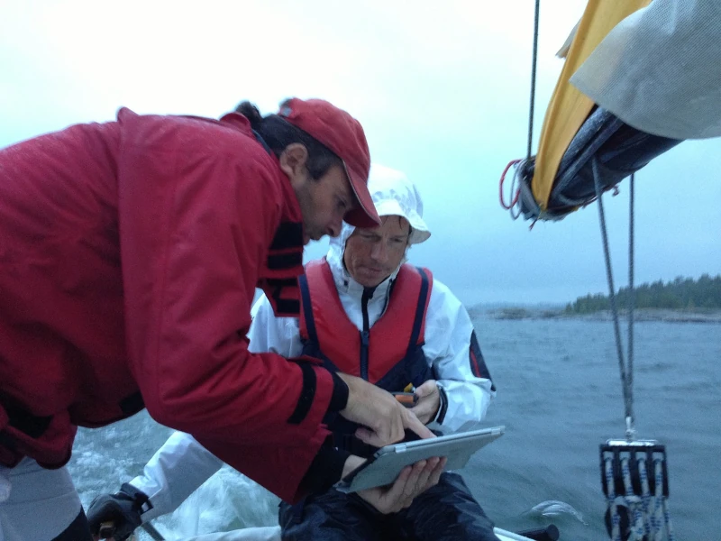 Two men navigating a sailboat